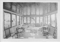 SA0495 - Photo of a porch-like place with rocking chairs and tables. Identified on the back.